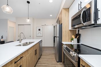 A modern kitchen with a stainless steel refrigerator and wooden cabinets.